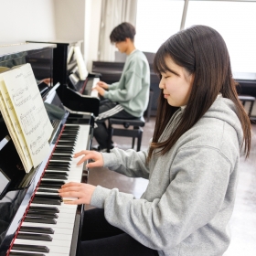 休み時間や放課後を使って自主練習。ピアノの練習も、幼稚園の先生や保育士には重要なスキル。実習先で子どもたちと一緒に歌う曲を練習したり、就職が決まっている人は、就職先してから毎月子どもたちと歌う曲を練習したり。５階のピアノ室には40台以上のピアノやクラビノーヴァがあり、自由に練習できます。